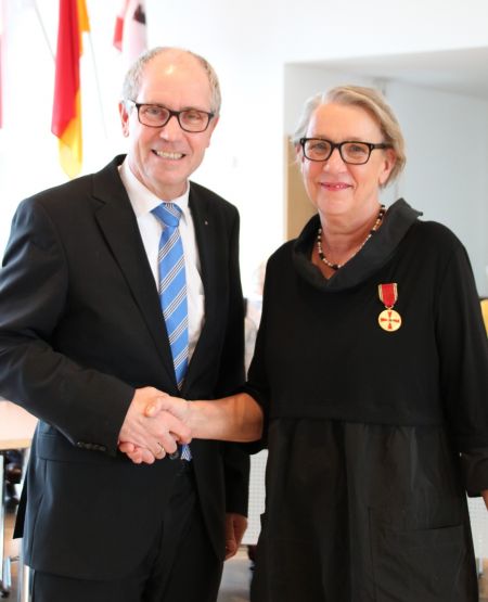 Magdalene Arndt (rechts im Bild) aus Paderborn hat hingesehen, das Schweigen durchbrochen und die verborgene Gewalt gegen Frauen hinter vermeintlich intakten Fassaden thematisiert. Auch dafür gab es die Verdienstmedaille der Bundesrepublik Deutschland. Landrat Manfred Müller (links im Bild) gratuliert Magdalene Arndt. (Foto: © Amt für Presse- und Öffentlichkeitsarbeit, Kreis Paderborn, Ulrike Sander)